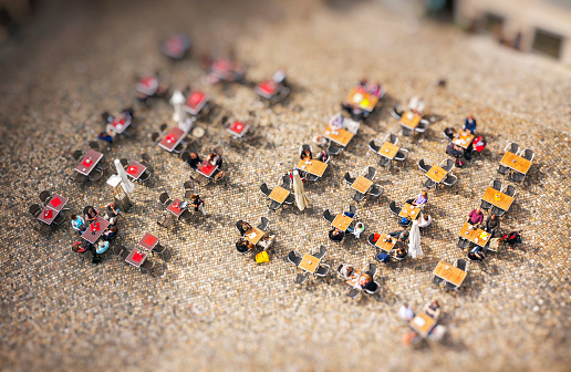 People sitting at outdoors cafe on the city square. Top view. Tilt-shift Miniature Effect