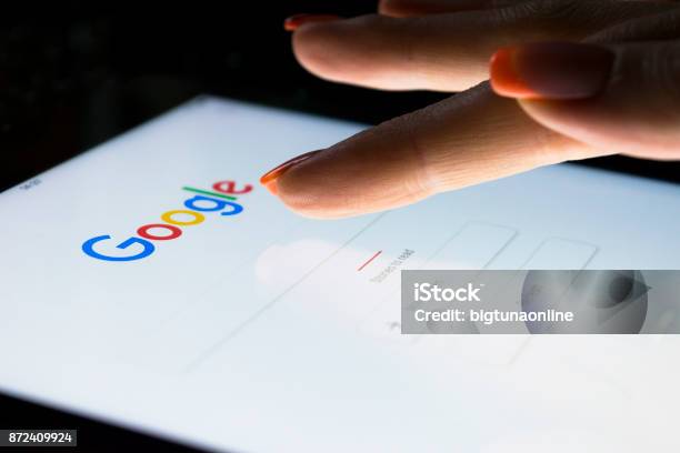 A Womans Hand Is Touching Screen On Tablet Computer Ipad Pro At Night For Searching On Google Search Engine Google Is The Most Popular Internet Search Engine In The World Stock Photo - Download Image Now