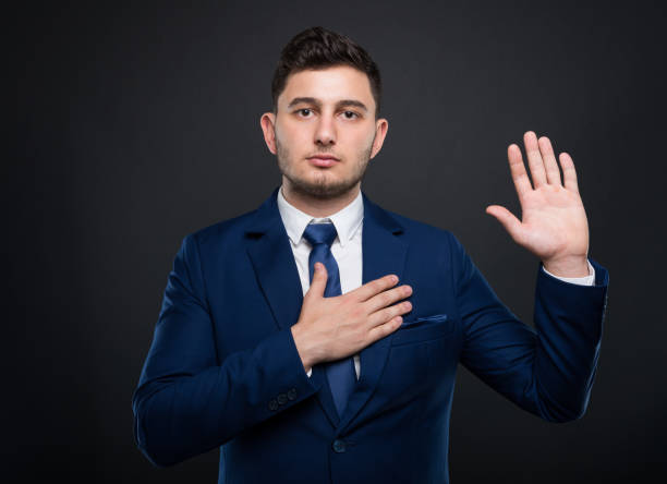 Businessman holds his hand on his chest stock photo