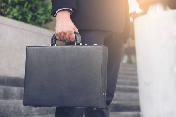 istock Businessman standing and holding a briefcase in hand working with confidence 872412180