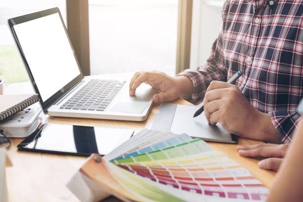 istock Young colleagues designers working together on a creative project and color samples for selection, Color swatch samples, Brainstorming Planning Partnership, creative graphic design working desktop 872412198