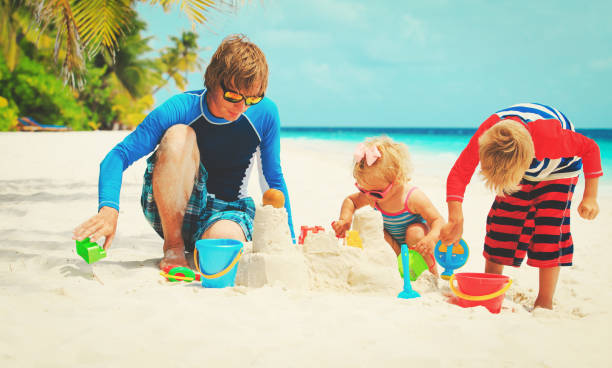istock father with son and daughter play on beach 872416930
