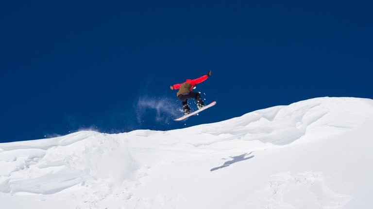 Snowboarder unsuccessfully performing a stunt, falling