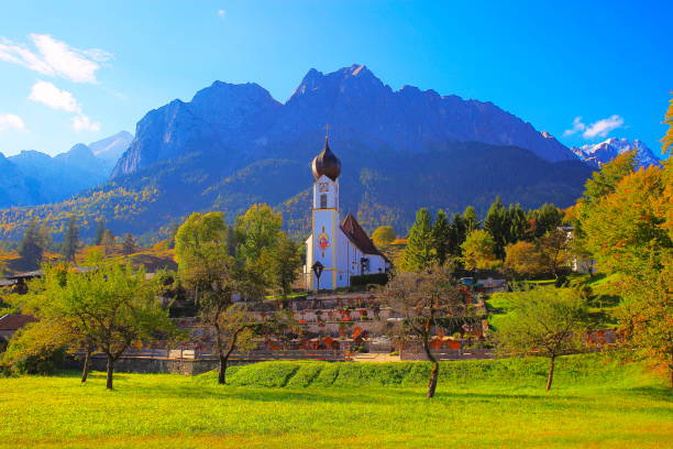 chiesa barocca nel villaggio alpino di grainau con vista su zugspitze, waxenstein e alpi, paesaggio drammatico nelle alpi bavaresi, germania - maestoso paesaggio alpino in autunno - garmisch, baviera, germania - waxenstein foto e immagini stock