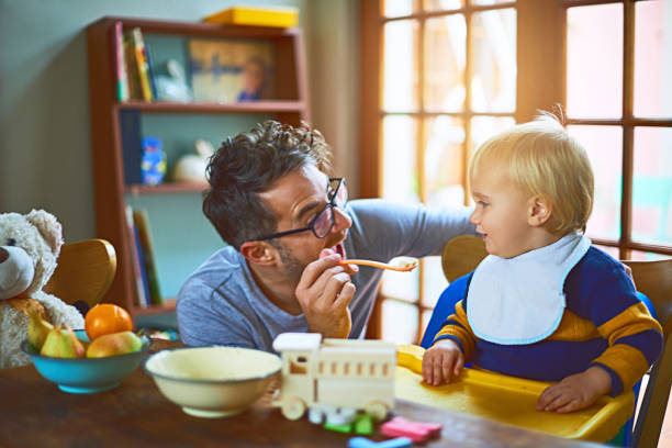 papai sempre faz o divertimento de tempo de alimentos - cereais de pequeno almoço - fotografias e filmes do acervo