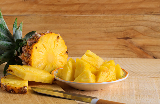 Ripe pineapple slice on a wooden table