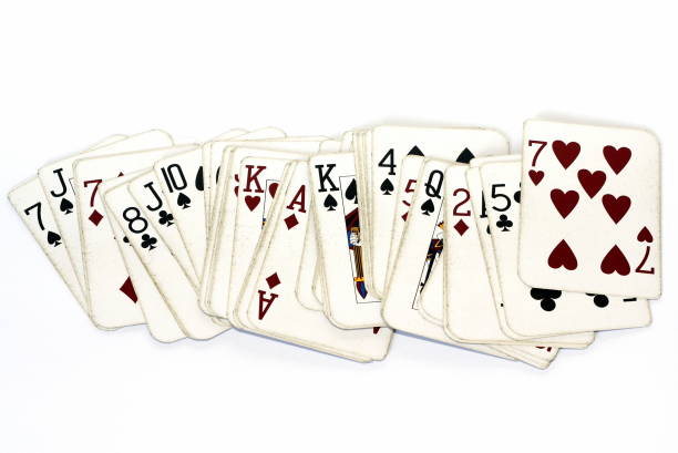 A deck of old fashioned playing cards spread out on a white background
