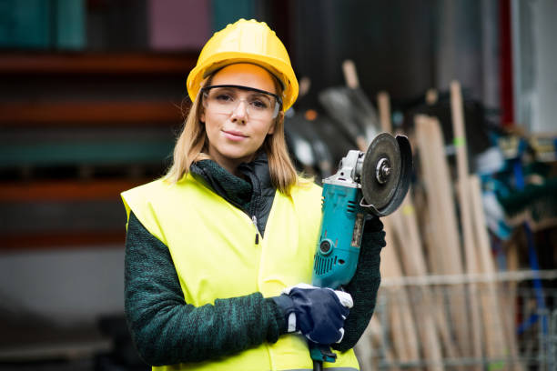 istock Female worker with angle grinder in a warehouse. 872440364