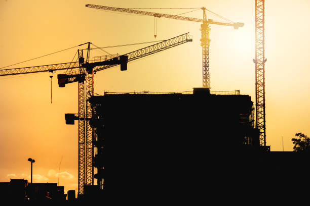 istock construction site at sunset with silhouettes of tower cranes 872445166