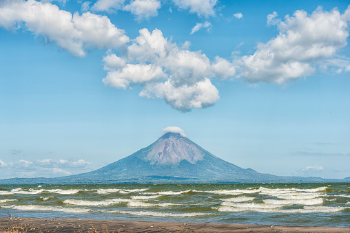 View over the lake Nicaragua on volcano Conception with smoky peak against blue sky on Island Ometepe, Nicaragua.