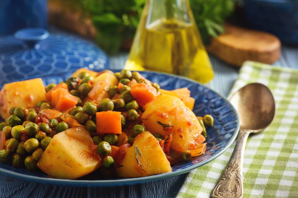 Vegetarian food - potatoes with pea and tomatoes, greek style cuisine. stock photo