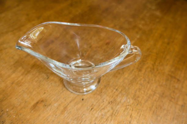 istock Empty glass sauce boat on wooden table 872456812