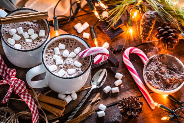 istock Two homemade hot chocolate mugs with marshmallows on rustic wooden Christmas table 872457196