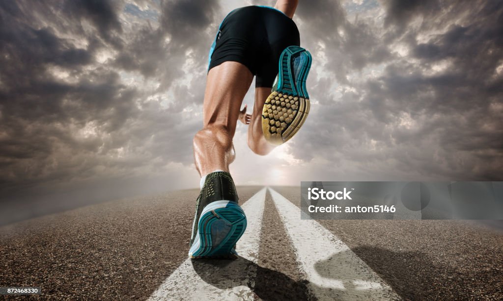The close up feet of man running and training on running track The close up feet and back of man running and training on running track. Advertising image about sport and healthy lifestyle Running Stock Photo