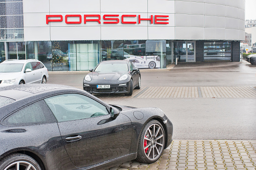 18.12.2016, Prague, Czech Republic: Closeup of Porsche cars in front of car dealership Porsche. Luxury fast and expensive cars standing in row.