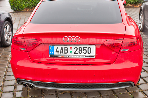 PRAGUE, THE CZECH REPUBLIC, 18.12.2016 - Closeup of new red car Audi A5 TDI quattro parking in front of car dealership Audi