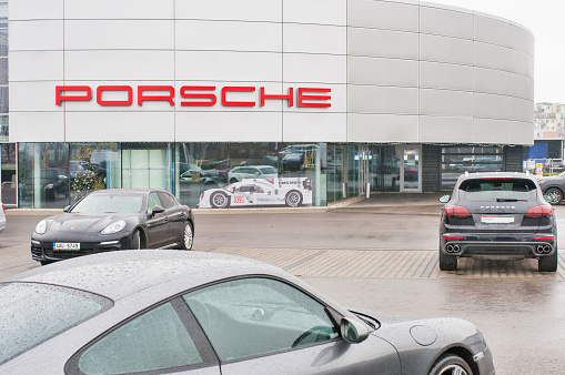 18.12.2016, Prague, Czech Republic: Closeup of Porsche cars in front of car dealership Porsche. Luxury fast and expensive cars standing in row.