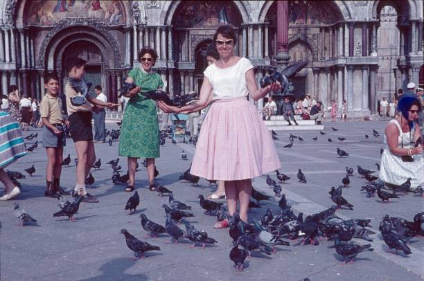 Venice, Venecia, Italy, 1961. Almost every major city in Europe and the world has a famous place or center. On these places, you can almost always find a colony of Culture successors. Mostly it is the pigeon. Thus, in recent decades and thanks to the invention of the camera, fashion and time spirit has been well and sufficiently documented by the emerging urban tourism.