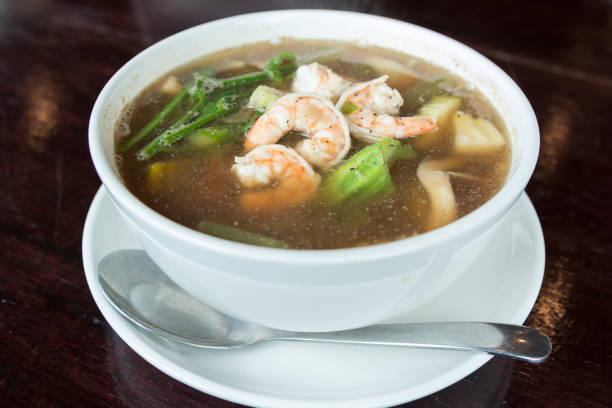 istock Spicy vegetable and prawn soup in bowl on wooden table 872476740