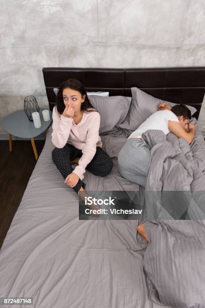 Young Woman Covers Her Nose Because Of Her Boyfriend Who Farted While Sleeping In The Bed Stock Photo - Download Image Now