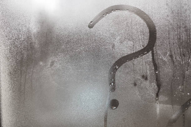 istock Blurry question mark on foggy condensation window glass natural surface background 872491128