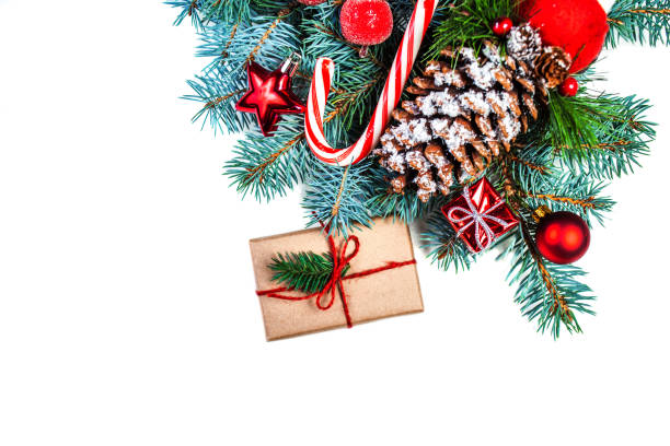 Christmas or New Year decorations background with pine cones, fir branches, gift boxes, red berries and candy isolated on white background