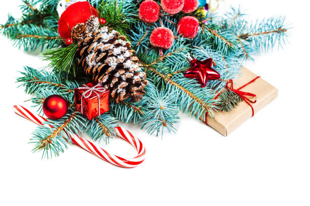 istock Christmas or New Year decorations background with pine cones, fir branches, gift boxes, red berries and candy isolated on white background 872494768