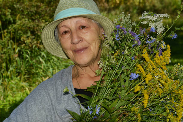 istock senior woman's portrait with flowers 872496250