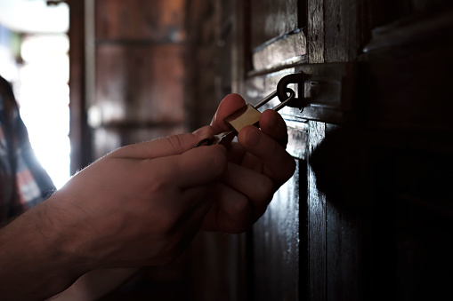 Caucasian man opening old wooden door. Close up view