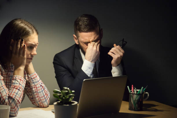 istock Two colleagues meeting in dark evening office to solve a problem 872526566