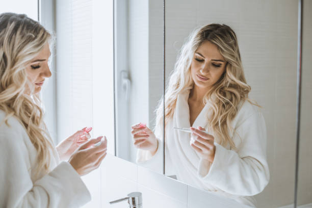 istock Woman in front of a mirror watching a pregnancy test 872530150