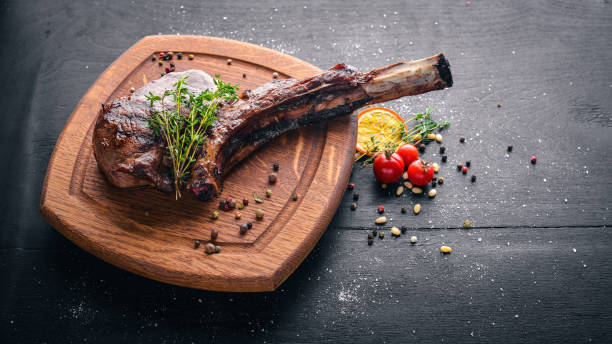 istock Steak on the bone. Top view. Free space for text. On a wooden background. 872530364