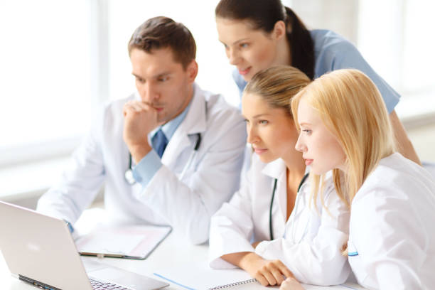 istock busy group of doctors looking at laptop computer 872533796