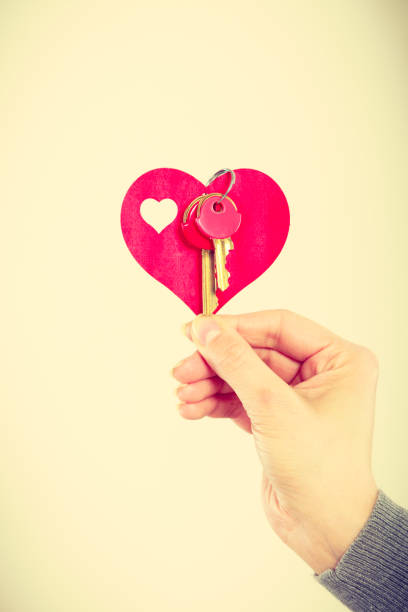 istock Female hand holds little heart with keys. 872538196