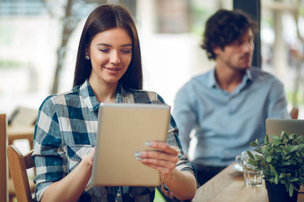 istock Young casual business woman using digital tablet in cafe. 872538548