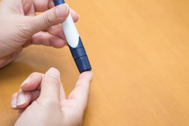 istock Close up of man hands using lancet on finger to check blood sugar level by Glucose meter using as Medicine, diabetes, glycemia, health care and people concept. 872539442