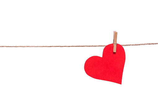 Red paper heart and clothespin on a rope isolated on white background