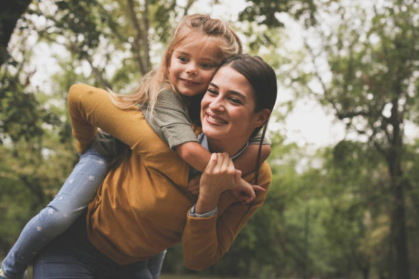 istock Mother carrying child on piggyback. 872554114