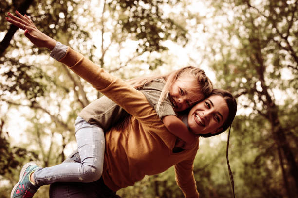 istock Mother have fun with daughter. Carrying her on piggyback. 872554332