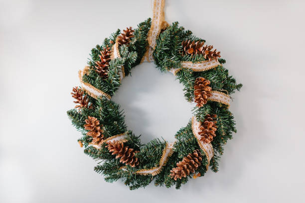 istock Handmade christmas wreath hanging on the white wall 872554954