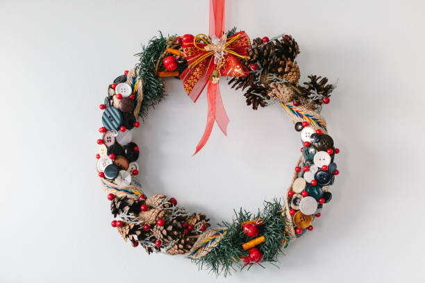 istock Handmade christmas wreath hanging on the white wall 872554960