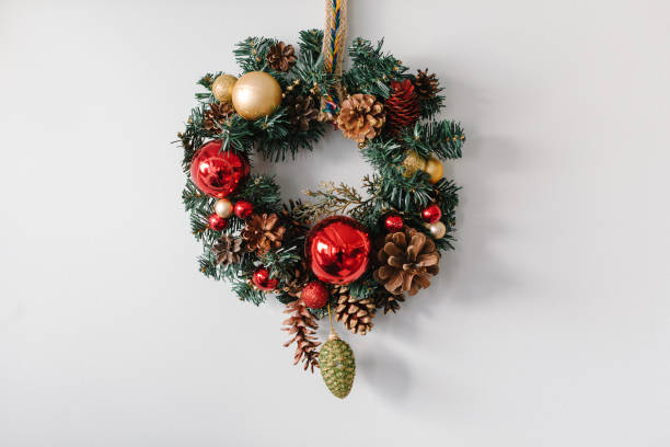 istock Handmade christmas wreath hanging on the white wall 872555030