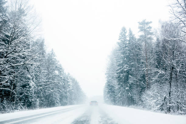 istock Car driving through a snowy highway in a winter snowstorm 872564974