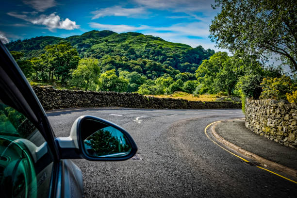 Driving through a country road in the lake district in England, UK Lake District saloon car stock pictures, royalty-free photos & images