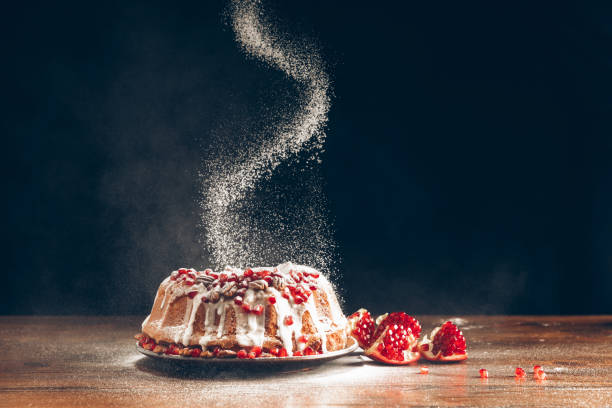 christmas cake powdering with icing sugar traditional homemade christmas cake with pomegranate powdering with icing sugar powdered sugar stock pictures, royalty-free photos & images