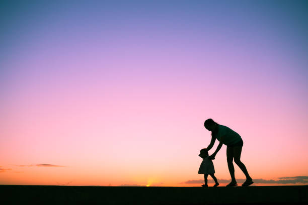 madre e hija caminando al aire libre. - holding hands child silhouette family fotografías e imágenes de stock