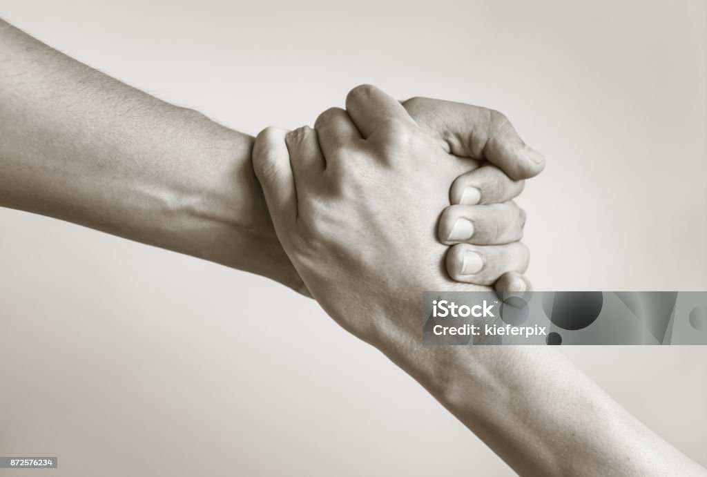 Rescue Black and white image of a close up of man's and woman's hand helping. A Helping Hand Stock Photo