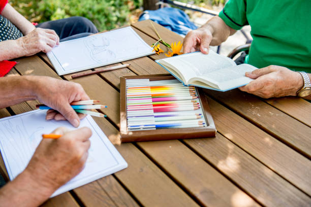istock Seniors Coloring and Reading Outdoors 872586914