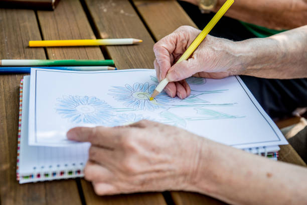 istock Senior Woman Coloring a Coloring Sketch 872586950