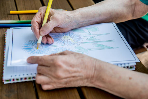 istock Senior Woman Coloring a Coloring Sketch 872586954